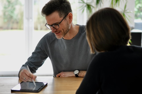 Der systemische Business Coach und Resilienz-Trainer Jan Pichert in einer Coaching-Session mit einer Klientin. Sie erarbeiten gemeinsam eine Lösung mit Hilfe eines Tablets.